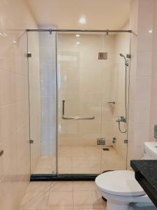 a shower stall in a bathroom with a toilet at Tuần Châu - Phương Đông Motel Hạ Long in Ha Long