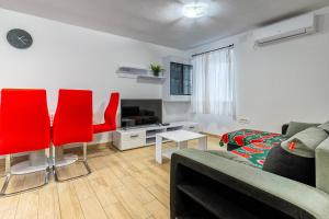 a living room with a couch and red chairs at Apartman Robert Cres in Cres