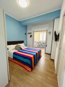 a bedroom with a bed with a colorful blanket on it at SicilyHouse Palermo in Palermo