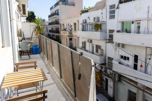 einen Balkon mit zwei Bänken und einigen Gebäuden in der Unterkunft H-nachala in Tel Aviv