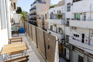 a balcony with two benches and some buildings at H-nachala in Tel Aviv