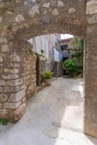 a stone alley with an archway in a building at Apartman Robert Cres in Cres