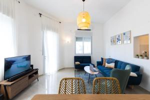 a living room with a blue couch and a tv at H-nachala in Tel Aviv