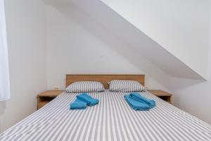 a bed with two blue slippers on top of it at Apartman Robert Cres in Cres