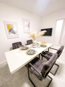 een eetkamer met een witte tafel en stoelen bij Olea apartments in Pobegi