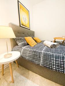a bedroom with a bed with yellow pillows and a table at Olea apartments in Pobegi