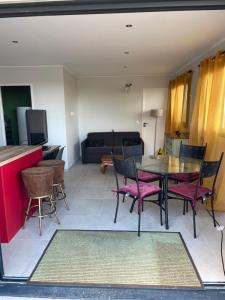 a living room with a table and chairs and a couch at Location Furiani t2 de standing in Furiani