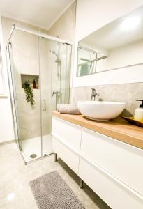 een badkamer met een wastafel en een douche bij Olea apartments in Pobegi