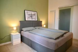 ein Schlafzimmer mit einem großen Bett mit einem Nachttisch und einem Bild in der Unterkunft Modernes Apartment in Berlin in Berlin