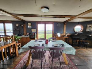 a dining room with a table and chairs and a piano at Inner Dowsing Lightship in Rochester