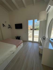 a bedroom with a bed and a desk and a television at Martanna Rooms in Carini