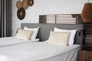 two beds in a bedroom with white sheets and pillows at GRANO HOTEL Solmarina in Wiślinka