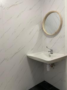 een witte badkamer met een wastafel en een spiegel bij Good Vibes in Christchurch