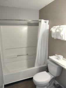 uma casa de banho branca com um WC e um chuveiro em Suburban Studios Stuart near Federal Hwy 1 em Stuart