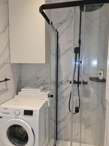 a washing machine in a bathroom with a shower at Apartman Nika Makarska in Makarska +9 photos