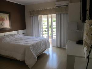 Un dormitorio con una cama y una puerta corrediza de vidrio. en REDE BONNEL 88 Confort, en Cachoeira do Sul 50 fotos más
