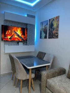 a dining room with a table and a fireplace at Appartement de luxe a Rimal Martil 1 min de la plage in Martil