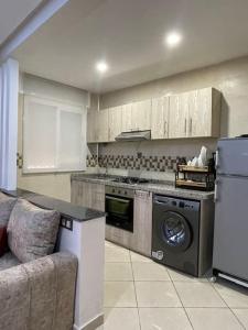 a kitchen with a stove and a washer and dryer at Appartement de luxe a Rimal Martil 1 min de la plage in Martil