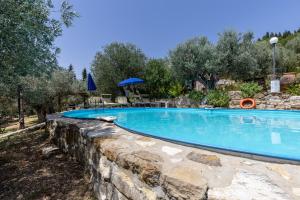 uma piscina com uma parede de pedra à volta em Poggio alla Pieve - Blu em Calenzano