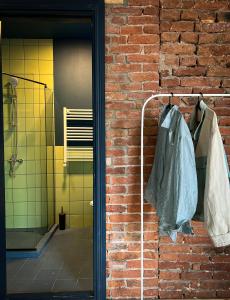 a brick wall with a towel hanging on a rack at Black Tomato Hostel Kutaisi in Kutaisi