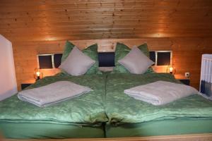 a large green bed with two pillows on it at Am Bergangerl in Ettal