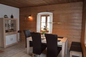 a dining room with a table and black chairs at Am Bergangerl in Ettal