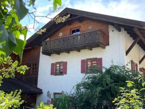 a building with a wooden balcony on top of it at Am Bergangerl in Ettal