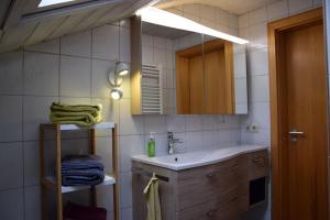 a bathroom with a sink and a mirror and towels at Am Bergangerl in Ettal