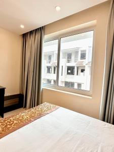 a bedroom with a bed and a large window at Tuần Châu - Phương Đông Motel Hạ Long in Ha Long