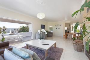 salon z kanapą i stołem w obiekcie Sea View Hilltop Villa, Blouberg w Kapsztadzie
