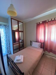 1 dormitorio con cama, mesa y espejo en Αρέθουσα easy view, en Chalkida