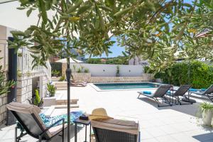 un patio con sillas y una piscina en Apartments Villa Key en Cavtat