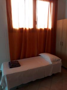 a bed in a room with a window with curtains at Casa Equilium 1 in Jesolo