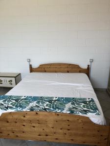 un letto con struttura in legno e coperta di Casa Equilium 1 a Jesolo