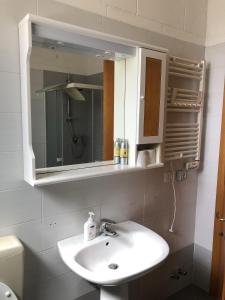 a bathroom with a sink and a mirror and a toilet at Casa Equilium 1 in Jesolo