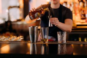 un homme est en train de prendre un verre au bar dans l'établissement YOTEL Geneva Lake, à Founex