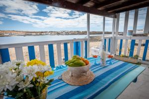a table with a bowl of fruit and flowers on a balcony at Cabin in front of idyllic majanicho beach in Majanicho