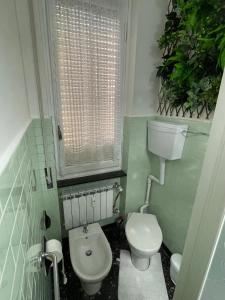uma casa de banho com um WC branco e uma janela em La Maisonette apartment em Serravalle Scrivia