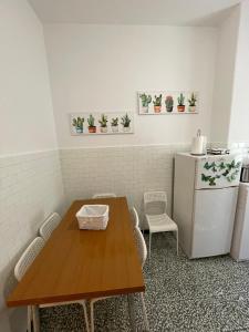 una cucina con tavolo in legno e frigorifero di La Maisonette apartment a Serravalle Scrivia