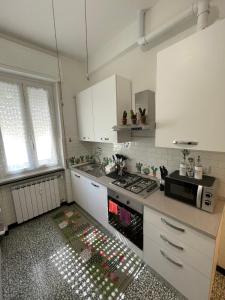 una cucina con armadi bianchi e piano cottura di La Maisonette apartment a Serravalle Scrivia