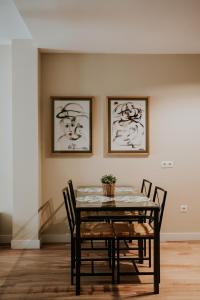 a dining room table with chairs and paintings on the wall at Apartamentos Poniente - Mares in Torre del Mar