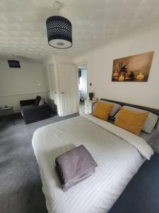 a bedroom with a large white bed with a purple blanket at Lovely City Studio near Station. Off Road Parking. in Norwich