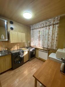 uma cozinha com máquina de lavar e secar roupa num quarto em 3 комнатная квартира Аэропорт em Turksib