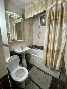 uma casa de banho com um WC, um lavatório e uma banheira em 3 комнатная квартира Аэропорт em Turksib