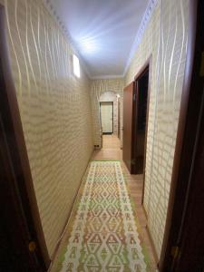 um corredor com um tapete estampado na parede em 3 комнатная квартира Аэропорт em Turksib