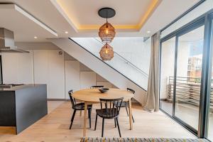 a dining room with a table and a staircase at Scholtz Penthouse in Cape Town