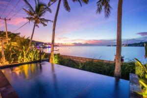 uma villa com uma piscina de beiral infinito e vista para a água em Sunset House Ceningan, 10 person beachfront private villa em Nusa Lembongan