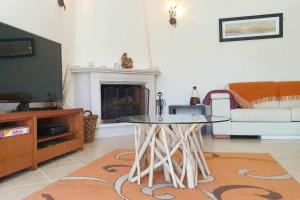 a living room with a table and a tv at Villa Amoreira V3 piscina Óbidos 