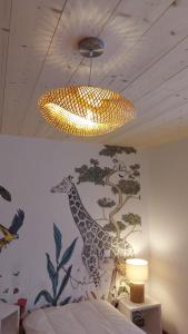 ein Schlafzimmer mit einem Giraffenbild an der Wand in der Unterkunft LE NID DES PLANCHETTES - Suite Chambres d'Hôtes 