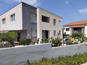 a white house with a fence in front of it at TiaMar in Slatine